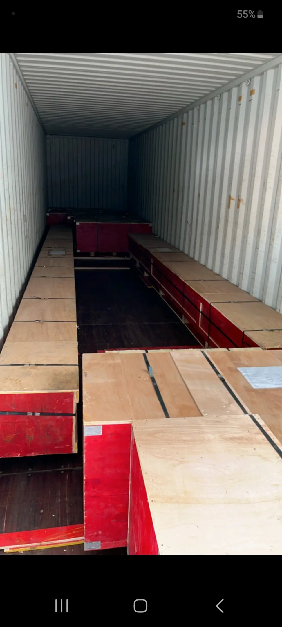 Red and wooden crates in a shipping container.